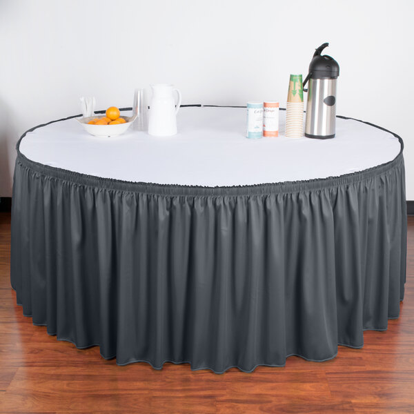 A table with a slate blue Snap Drape table skirt with Velcro clips on it.