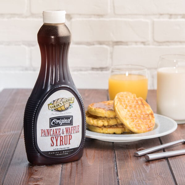 A Golden Barrel Pancake syrup bottle on a table next to a plate of waffles.