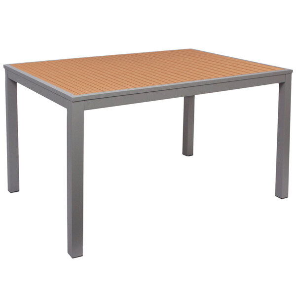 A BFM Seating bar height table with a rectangular synthetic teak top and silver aluminum legs.