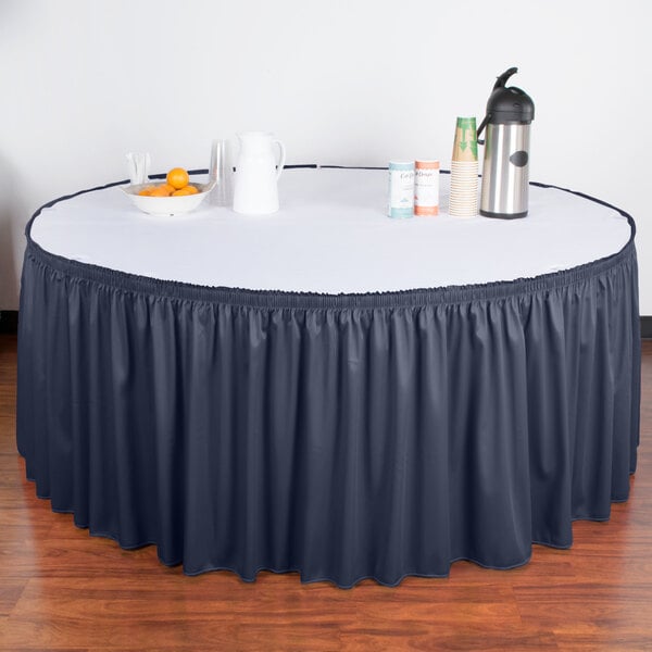 A table with a navy Snap Drape table skirt on it.