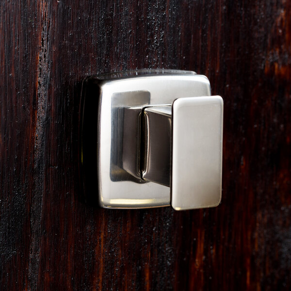 A close-up of a Bobrick bright polished metal robe hook.