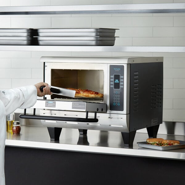 A chef using a TurboChef Tornado oven to cook a pizza.