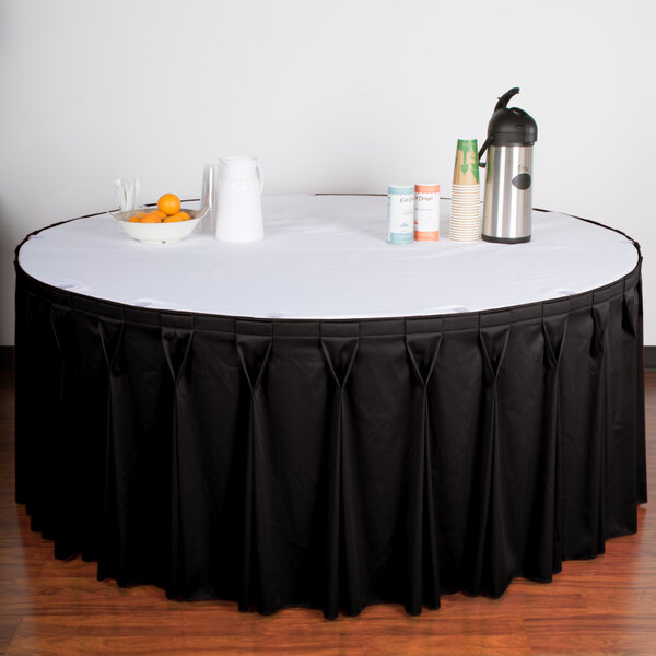 A table with a black Snap Drape Wyndham table skirt on a white table.