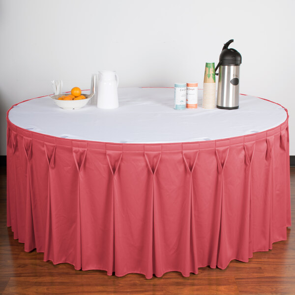 A table with a dusty rose Snap Drape table skirt on it.