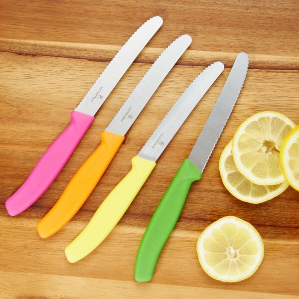 A Victorinox 4-piece utility knife set with colorful handles next to lemon slices.
