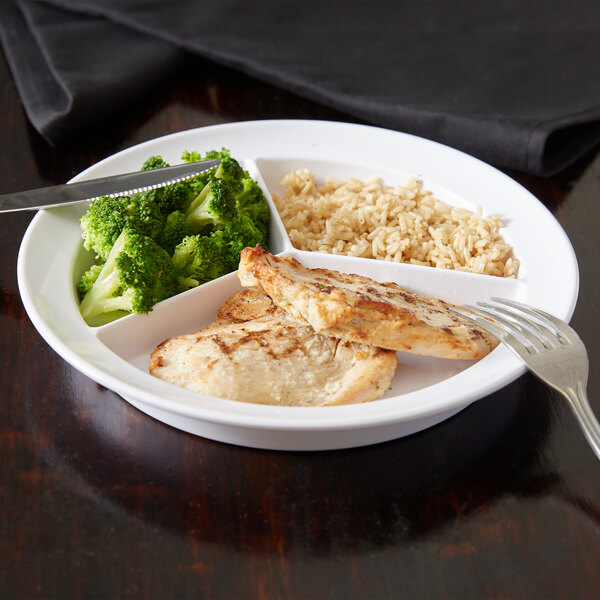 A Carlisle white melamine plate with rice, broccoli, and chicken on it with a fork and knife.