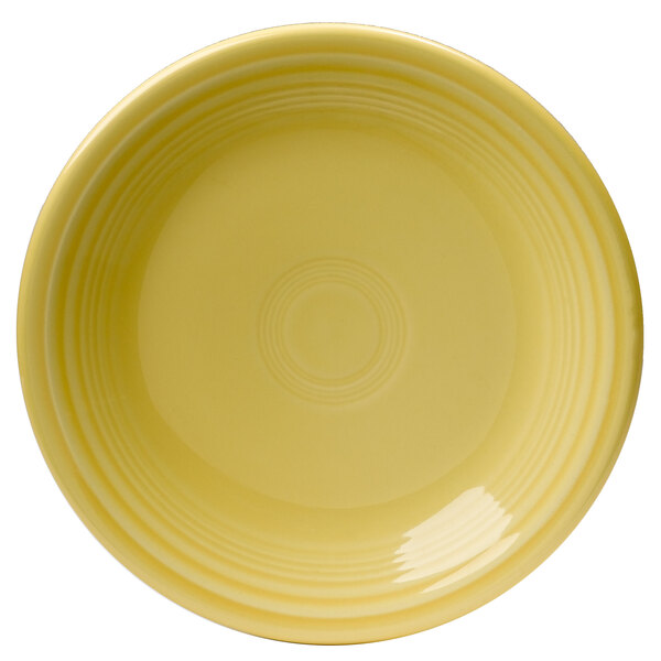A yellow Fiesta salad plate with a circular pattern on a white background.