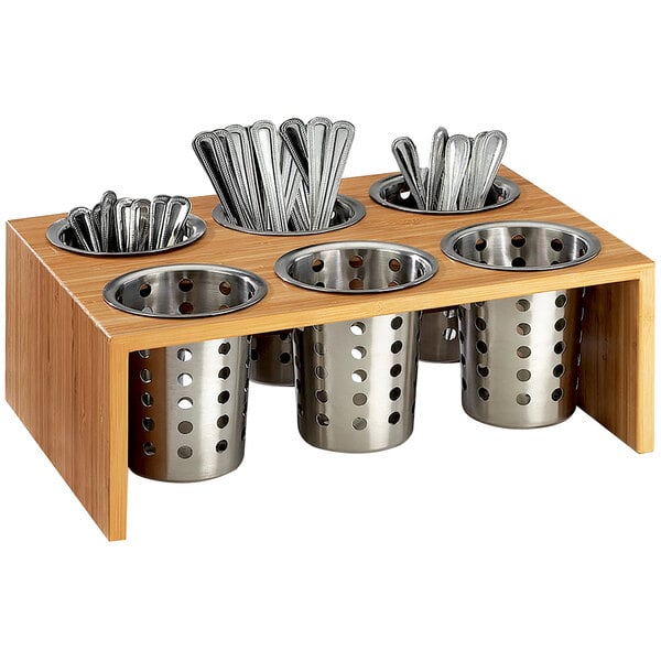 A bamboo tray with metal cylinders holding flatware.