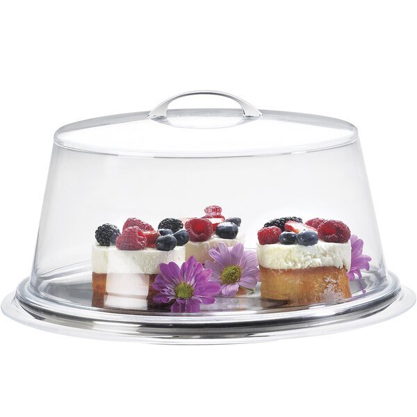 A Cal-Mil glass cake cover with a cake decorated with berries and flowers inside.