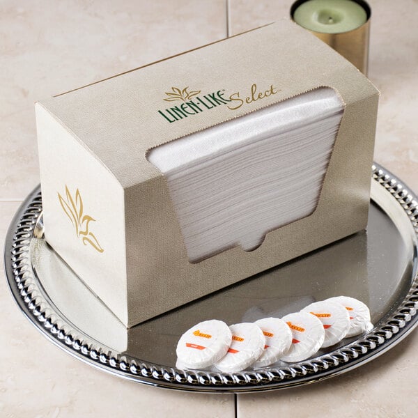 A white dispenser box of Hoffmaster Linen-Like guest towels on a silver tray.
