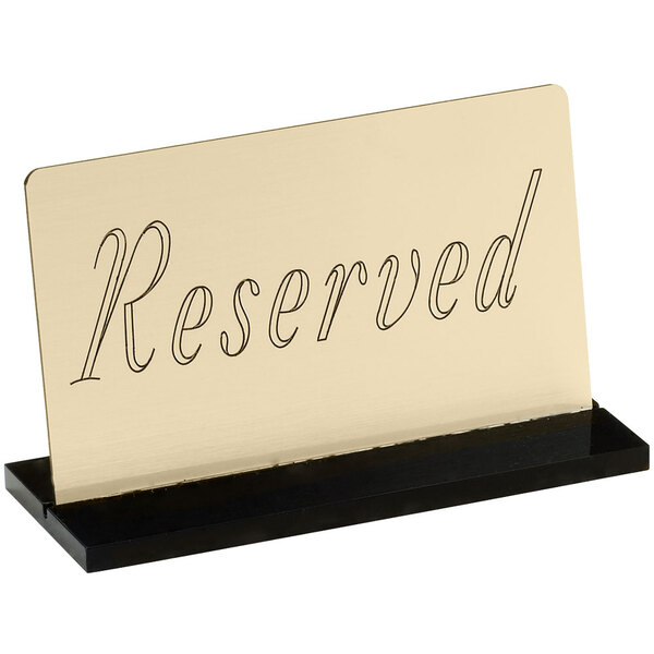 A gold and black Cal-Mil "Reserved" sign on a stand.