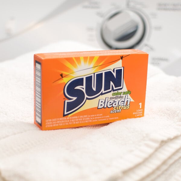 A box of Sun Color Safe Bleach powder packets on a towel.