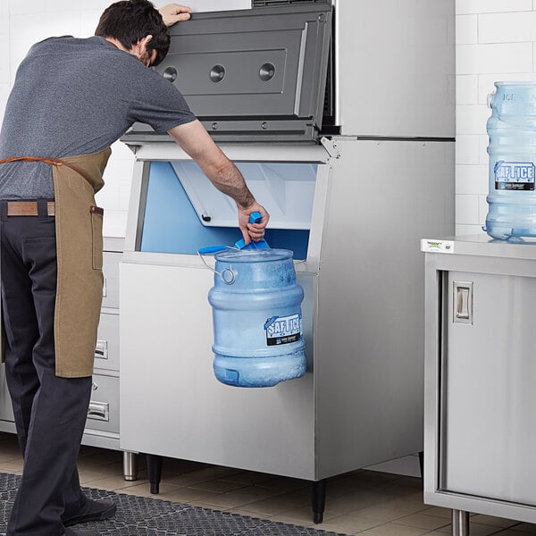 A man putting a container into a Hoshizaki stainless steel ice storage bin.