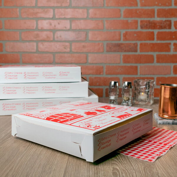 A white pizza box with red checkered designs on a table.