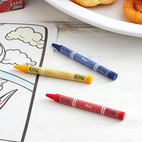 A yellow cellophane-wrapped package of Choice Kids' Restaurant Crayons on a table with a plate of food and a donut.