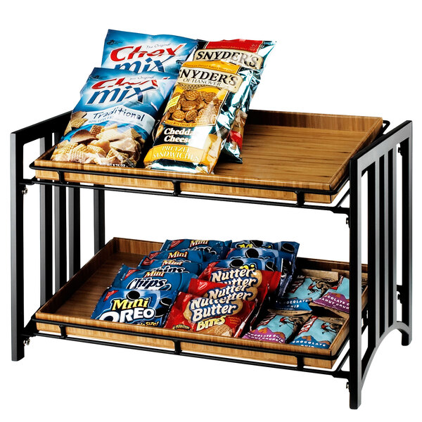A Cal-Mil two tier merchandiser shelf with snacks on it.
