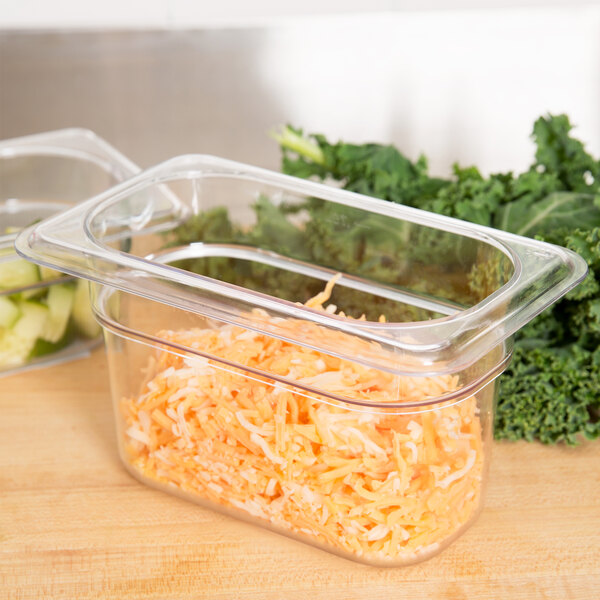 A Carlisle clear polycarbonate food pan with shredded carrots inside.
