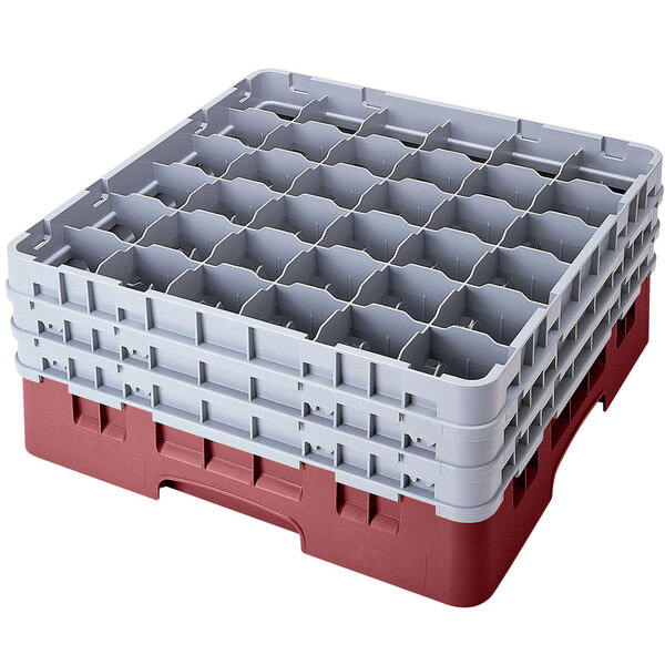 A stack of red and gray plastic Cambro glass racks with extenders.