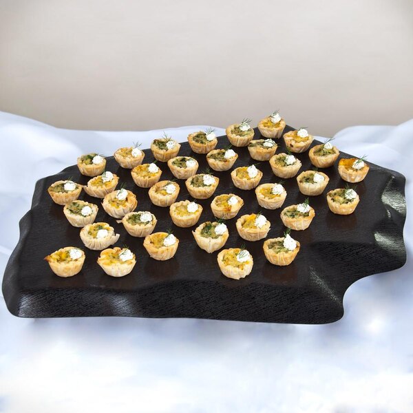 A black GET Stone-Mel melamine tray with appetizers on it on a table.