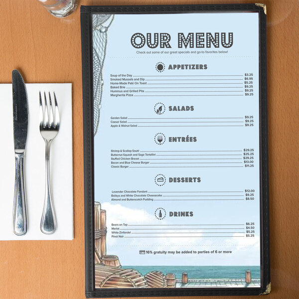 Menu paper with a seafood themed port design on a wood table with a knife and fork.