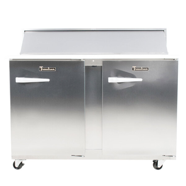 A stainless steel Traulsen sandwich prep refrigerator on wheels with two right hinged doors.