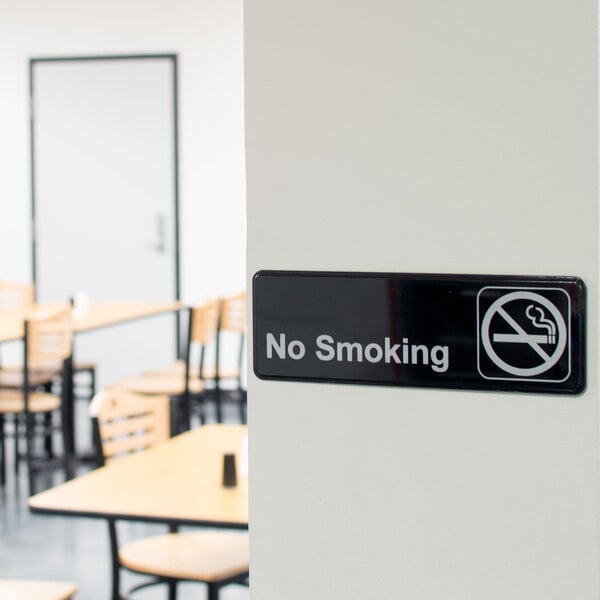 A black and white Thunder Group no smoking sign on a wall.