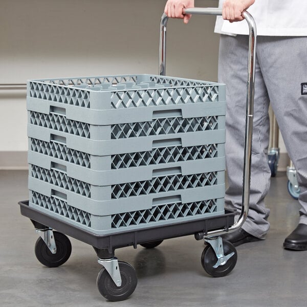 A man pushing a Vollrath Traex rack dolly with a stack of crates.
