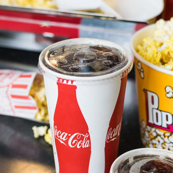 A clear plastic Solo lid with straw slot and identification buttons on a soda cup filled with popcorn.