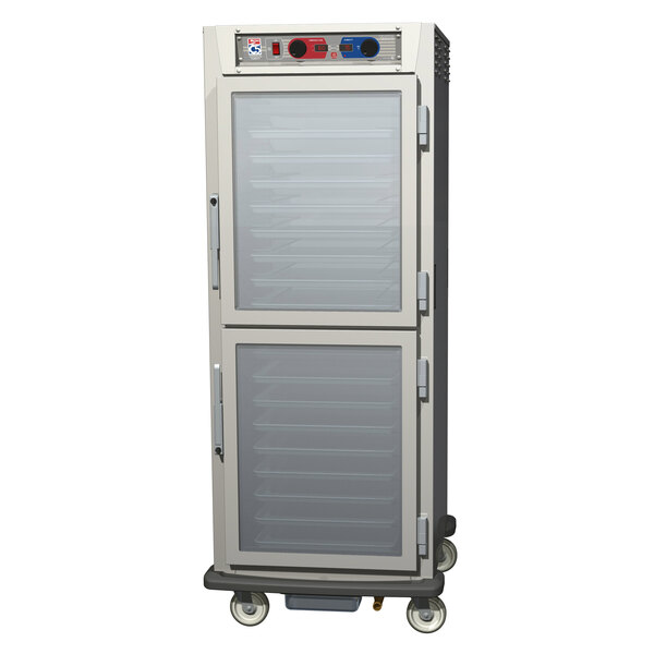 A stainless steel Metro C5 holding/proofing cabinet with clear Dutch doors on wheels.