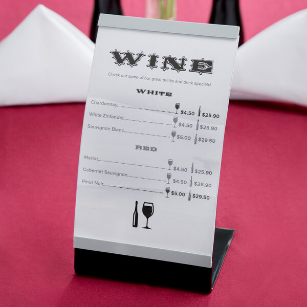 A Tablecraft curved menu displayette holding a white paper menu with black text on a table.