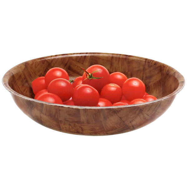 A Cambro dark basketweave fiberglass salad bowl filled with cherry tomatoes.