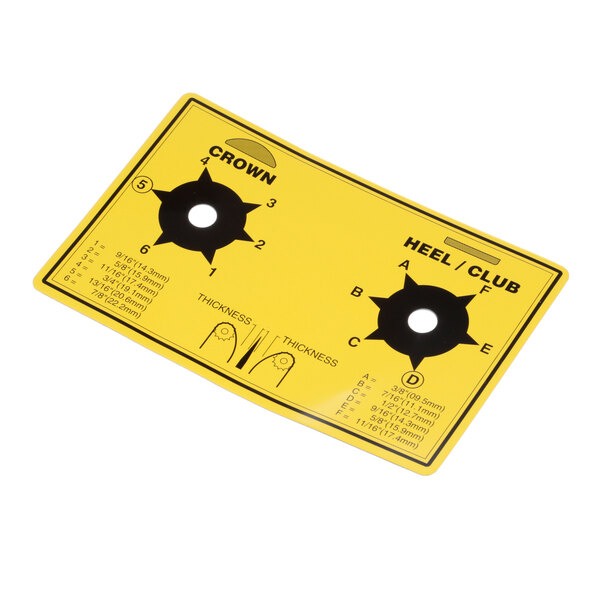 A yellow plastic card with black and white circles and two holes.