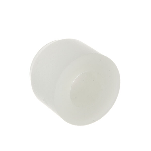A close-up of a white plastic cylinder with a hole.