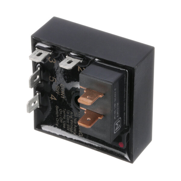 A close-up of a black square electronic device with a black cover, showing a small black relay with two wires inside.