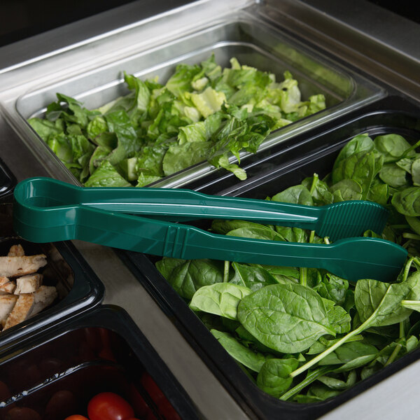Green Thunder Group polycarbonate tongs on a salad bar counter.