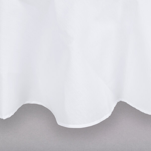 A close-up of a white Intedge round poly/cotton blend tablecloth.
