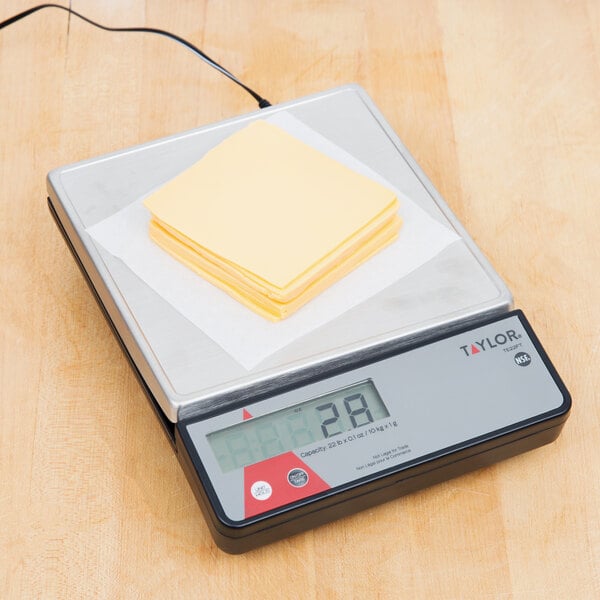 A Taylor digital portion scale with a stack of yellow sticky notes on it.