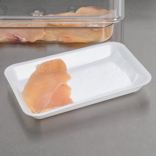 A white foam supermarket tray with a white absorbent meat pad holding a piece of meat.