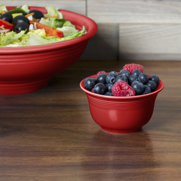 A Fiesta Scarlet China bowl filled with salad and fruit.