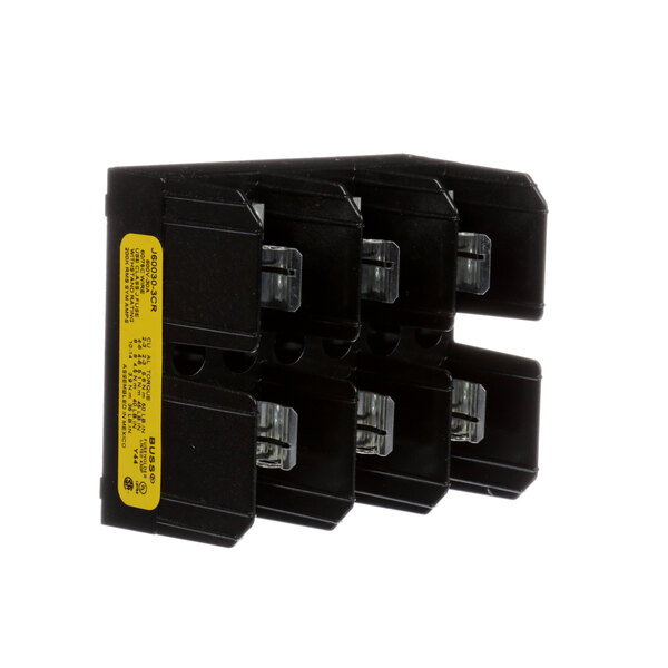 A black rectangular Champion fuse block with yellow labels on clear plastic parts.