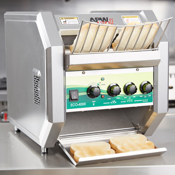 An APW Wyott conveyor toaster with bread slices on it.
