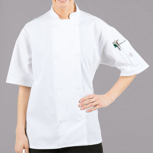 A woman wearing a white Mercer Culinary chef's jacket with a mesh back.