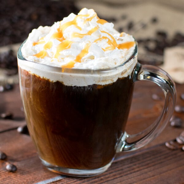 A Libbey square glass mug filled with a caramel coffee drink and whipped cream.