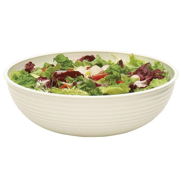 A white Cambro round ribbed bowl filled with a salad of lettuce and tomatoes.