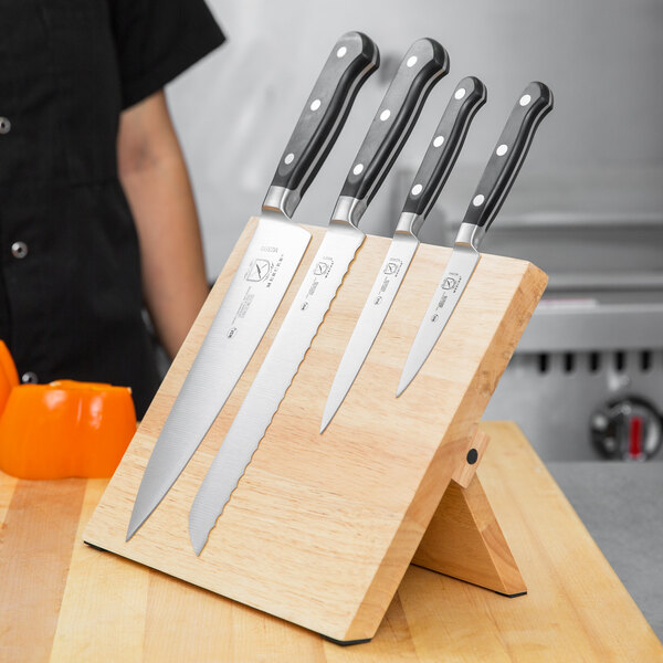 A Mercer Culinary Renaissance knife set on a wooden board with knives.