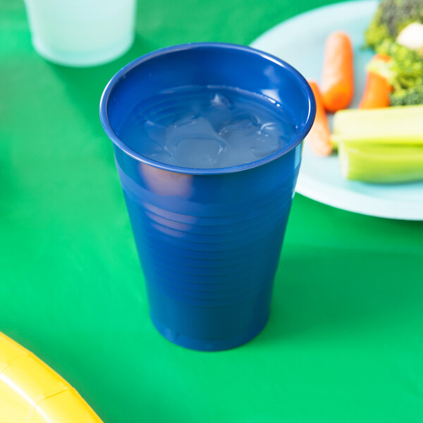 A navy blue Creative Converting plastic cup filled with ice.