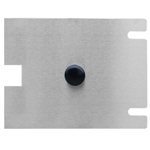 A metal plate with a black button that has a black circle on it.