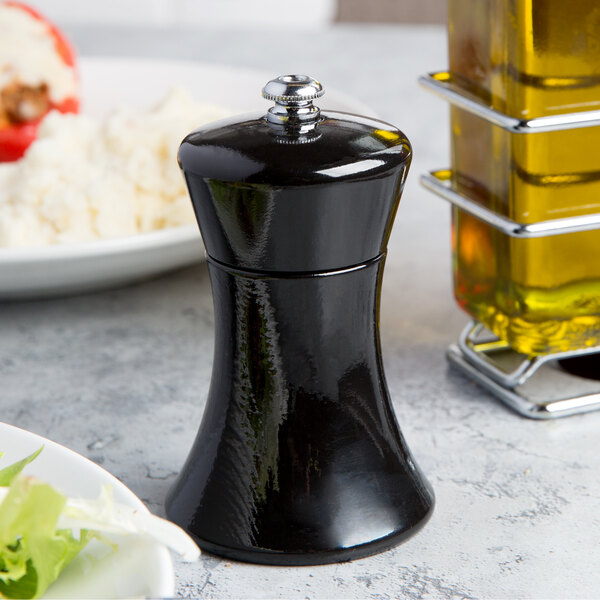 A Fletchers' Mill black pepper mill next to a plate of food.