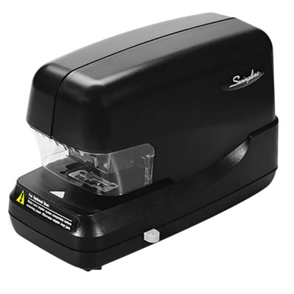 A black Swingline high-capacity stapler on a counter with a clear plastic cover.