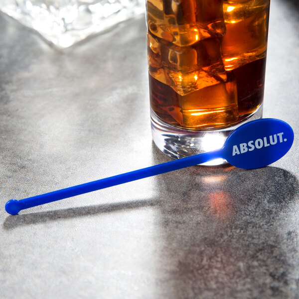 A glass with ice and a WNA Comet blue oval stirrer.